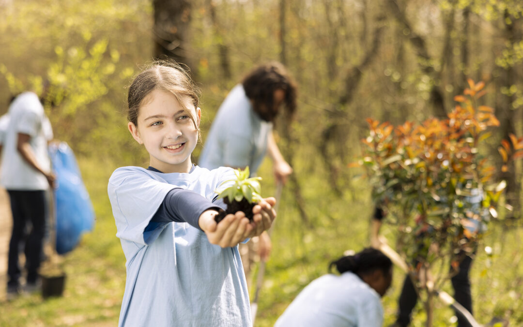 Youngster advocating for conservation of forest ecosystems by holding a little green seedling with organic soil.